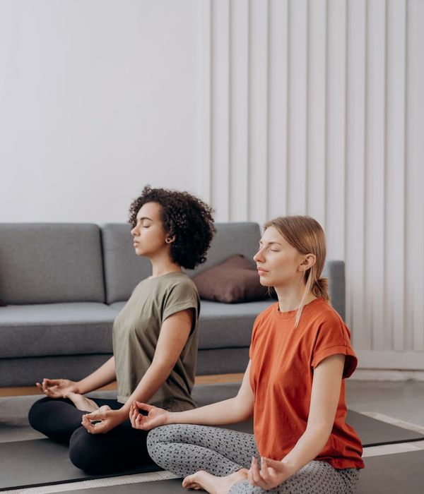 Person in a flowing yoga pose in a minimalist room.